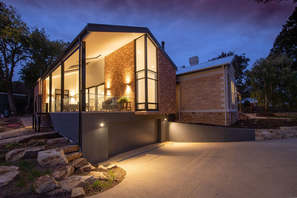 Modern home with large glass windows glowing at dusk
