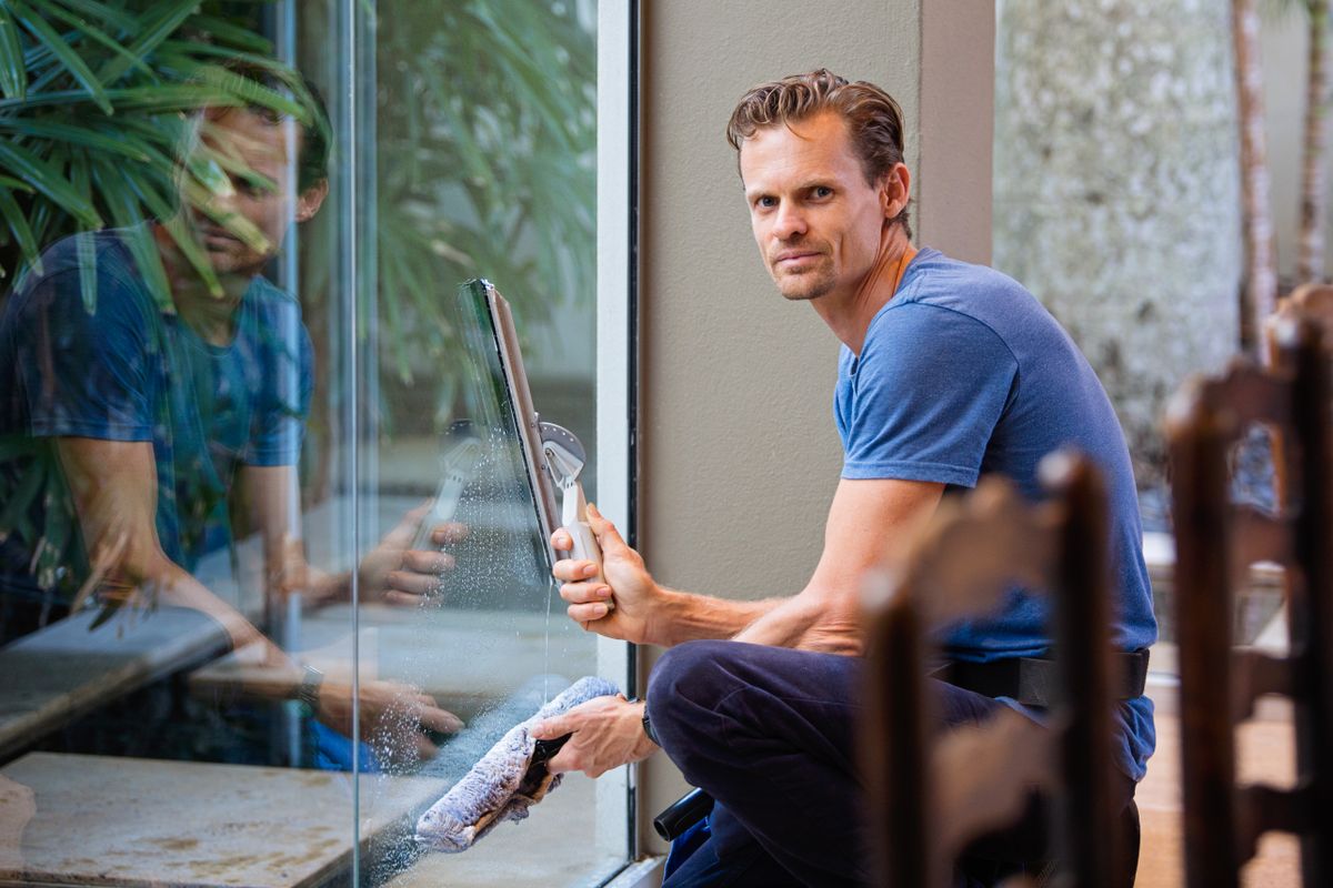 Installer working a squeegee across a large glass pane