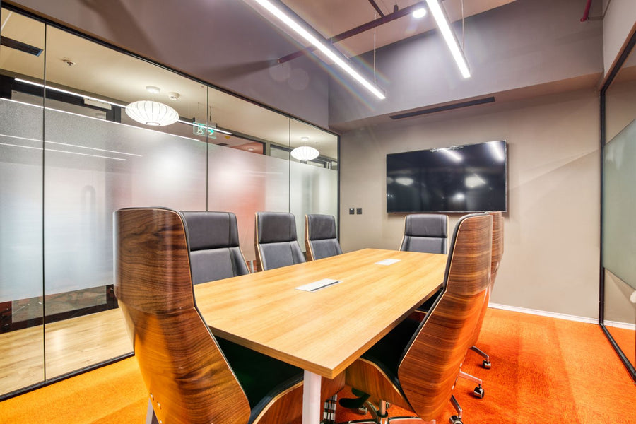Glass-walled conference room with a wall screen